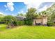 Beautiful backyard with lush green grass, landscaping, screened-in patio, and a glimpse of the pool at 2000 Bloomsbury Run, Lake Mary, FL 32746