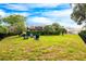 Spacious backyard featuring lush green grass, mature trees, and outdoor seating with a screened-in patio at 2000 Bloomsbury Run, Lake Mary, FL 32746
