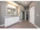 Bright bathroom with a marble countertop, white cabinets, large mirror, and gray tile floor at 2000 Bloomsbury Run, Lake Mary, FL 32746