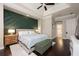 Main bedroom featuring a green accent wall, tray ceiling, and access to the ensuite bathroom at 2000 Bloomsbury Run, Lake Mary, FL 32746