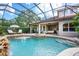 Backyard swimming pool and outdoor patio with waterfall feature, lounge chairs, and seating at 2000 Bloomsbury Run, Lake Mary, FL 32746