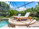 Inviting screened-in pool area with lounge chairs, an umbrella, and lush greenery at 2000 Bloomsbury Run, Lake Mary, FL 32746