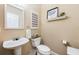 Half bath featuring a pedestal sink, toilet, mirror, and decor at 20603 Paddock St, Orlando, FL 32833