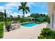 Backyard pool with covered seating, lush landscaping, and blue skies at 20603 Paddock St, Orlando, FL 32833