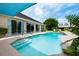 A luxurious backyard pool with seating, lush landscaping, and clear blue skies at 20603 Paddock St, Orlando, FL 32833