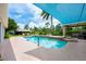 Backyard pool area featuring a refreshing pool with waterfall, covered patio, outdoor lounge chairs, and lush landscaping at 20603 Paddock St, Orlando, FL 32833