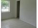 Cozy bedroom featuring tiled floors with a large window showcasing natural light at 2112 Lee St, Orlando, FL 32805