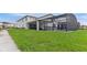Expansive backyard featuring a screen-enclosed pool area, lush lawn, and ample space for activities at 2114 Fleming Mist Pl, Kissimmee, FL 34747