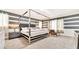 Elegant bedroom featuring a four-poster bed, chic furniture, and stylish striped accent wall at 2114 Fleming Mist Pl, Kissimmee, FL 34747