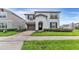 Two-story home with a well-manicured lawn, brick driveway, and stucco exterior at 2114 Fleming Mist Pl, Kissimmee, FL 34747