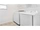 Well-lit laundry room featuring modern, white, side-by-side washer and dryer units at 2114 Fleming Mist Pl, Kissimmee, FL 34747
