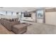 Comfortable living room with a large gray sectional sofa, entertainment center, and ample sunlight at 2114 Fleming Mist Pl, Kissimmee, FL 34747