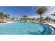 Gorgeous community pool with palm trees, cabanas, and ample seating for relaxation and leisure at 2114 Fleming Mist Pl, Kissimmee, FL 34747