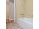 Bathroom featuring tub with yellow tiling and a doorway with hardwood floors beyond at 2151 Conifer Ave, Winter Park, FL 32792
