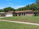 Inviting single-story home with an attached two-car garage and mature landscaping at 2151 Conifer Ave, Winter Park, FL 32792