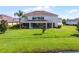 Back exterior view of home with a screened-in patio and a large grassy lawn at 2275 Pearl Cider St, Orlando, FL 32824