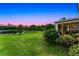 Enjoy outdoor living in this backyard featuring lush lawn and views of the tranquil lake at sunset at 2275 Pearl Cider St, Orlando, FL 32824