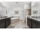 Bright bathroom boasts dual vanities, a soaking tub, and neutral tile flooring at 2275 Pearl Cider St, Orlando, FL 32824