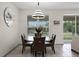 Dining area features a glass table, stylish light fixture, and backyard views at 2275 Pearl Cider St, Orlando, FL 32824