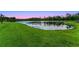 This idyllic pond view showcases the serene setting of the home with lush greenery at 2275 Pearl Cider St, Orlando, FL 32824