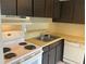 Classic kitchen featuring white appliances, a double sink, and dark cabinetry at 228 Everest Pt # 108, Casselberry, FL 32707