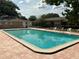 Community pool with clear blue water, surrounded by a red brick paver deck and black metal fencing at 228 Everest Pt # 108, Casselberry, FL 32707