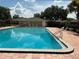 Community pool surrounded by lounge chairs and tables with a clear blue sky reflection at 228 Everest Pt # 108, Casselberry, FL 32707