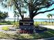 Community sign for Sweetwater Beach with lush landscaping and lake in the background at 2313 Park Village Pl, Apopka, FL 32712
