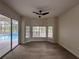Bright room with wood floors, three large windows, and view of screened-in pool area at 2313 Park Village Pl, Apopka, FL 32712