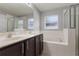 This bathroom features a soaking tub, a shower, and double sinks with brown cabinets at 2360 Brewerton Ln, Orlando, FL 32824