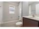 Bathroom with white tiling, a window, and a dark brown vanity at 2360 Brewerton Ln, Orlando, FL 32824