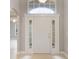 Bright entryway featuring a white door with sidelights and transom window, complemented by neutral tile flooring at 2360 Brewerton Ln, Orlando, FL 32824