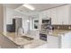 Well-lit kitchen with stainless steel appliances, granite countertops, and crisp white cabinetry at 2360 Brewerton Ln, Orlando, FL 32824