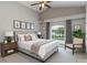 This staged main bedroom has a neutral color palette and an arched window overlooking the pool at 2360 Brewerton Ln, Orlando, FL 32824