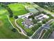 Birds-eye view of the golf clubhouse with landscaping, golf course, parking, and road access at 2362 Prairie Dunes, Clermont, FL 34711