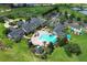 Aerial view of the community clubhouse, pool, tennis courts, and lush landscaping at 2362 Prairie Dunes, Clermont, FL 34711