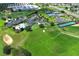 Extensive aerial view showcasing the clubhouse, pool, tennis courts, golf course, and surrounding area at 2362 Prairie Dunes, Clermont, FL 34711