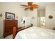 Cozy bedroom with soft carpet, ceiling fan, a dresser, and an attached bathroom at 2362 Prairie Dunes, Clermont, FL 34711