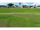 Scenic view of a well-maintained golf course with homes in the background, under a partly cloudy sky at 2362 Prairie Dunes, Clermont, FL 34711