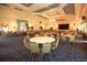 Large meeting room perfect for events with round tables and green, comfortable chairs and a stage at 2362 Prairie Dunes, Clermont, FL 34711