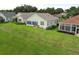 View of the home's back exterior, highlighted by a well-manicured lawn and sunroom at 2362 Prairie Dunes, Clermont, FL 34711