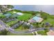 Scenic aerial view of community amenities featuring pool, tennis courts, and recreational facilities by a lake at 2388 Baronsmede Ct, Winter Garden, FL 34787
