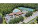 Aerial view of community pool, clubhouse, and tennis courts surrounded by mature trees at 2388 Baronsmede Ct, Winter Garden, FL 34787