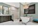 Luxurious bathroom featuring a freestanding tub beneath a chandelier and a walk-in shower at 2388 Baronsmede Ct, Winter Garden, FL 34787