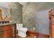 Elegant powder room with patterned wallpaper, decorative mirror, wood vanity, and beautiful fixtures at 2388 Baronsmede Ct, Winter Garden, FL 34787