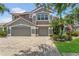 Lovely home with a three-car garage and brick driveway, complemented by verdant landscaping at 2388 Baronsmede Ct, Winter Garden, FL 34787