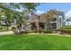 Beautiful two-story home showcasing lush landscaping, a well-manicured lawn, and a charming red tile roof at 2388 Baronsmede Ct, Winter Garden, FL 34787