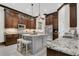 Gourmet kitchen features an island with bar stool seating, granite countertops, stainless appliances and custom cabinetry at 2388 Baronsmede Ct, Winter Garden, FL 34787