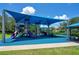 Shaded playground with multiple slides and climbing structures, perfect for Gathering fun and safe outdoor activities at 2388 Baronsmede Ct, Winter Garden, FL 34787