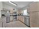 Well-lit kitchen featuring stainless steel appliances, tile flooring, and neutral-toned cabinets at 2515 La Jolla Trl, Kissimmee, FL 34747